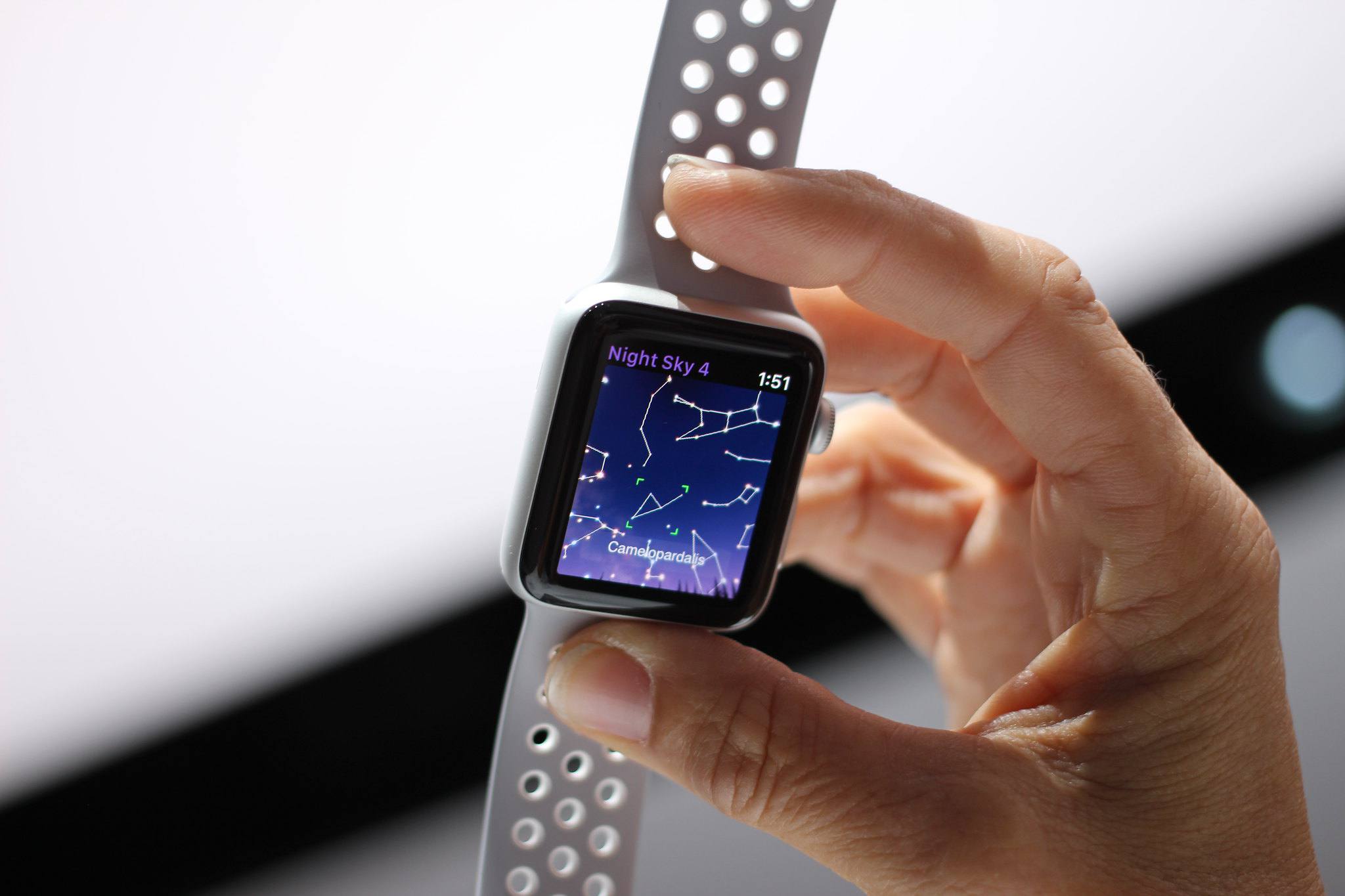Ruka držící hodinky Apple Apple Watch s Night Sky 4 na obrazovce