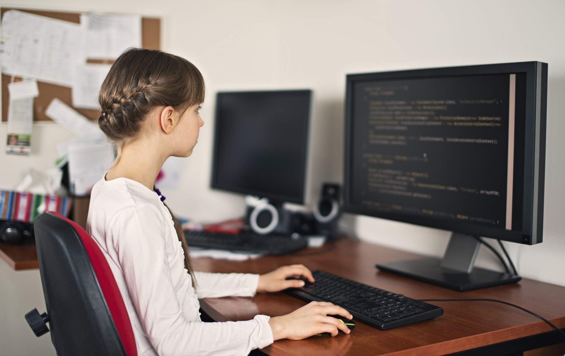 Student se učí kódovat na stolním počítači doma