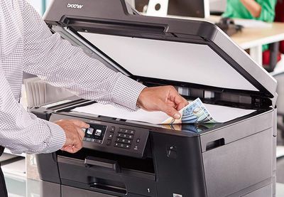 Člověk používající inkoustovou tiskárnu
