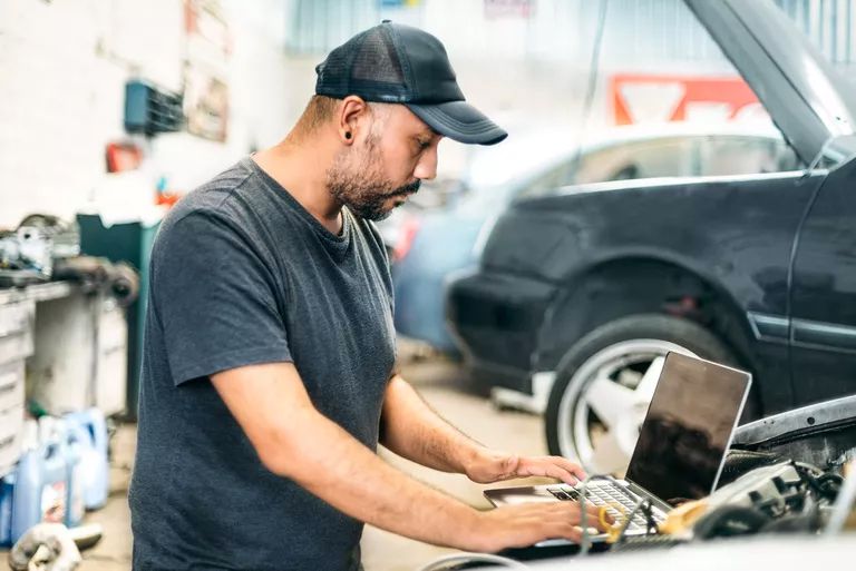 Auto technik s počítačem připojeným k autu