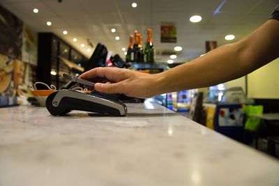 Osoba provádějící bezkontaktní platbu pomocí aplikace pro smartphone v pekárně.