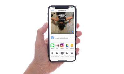 Ruka držící iPhone, video vybrané ke sdílení přes AirDrop.