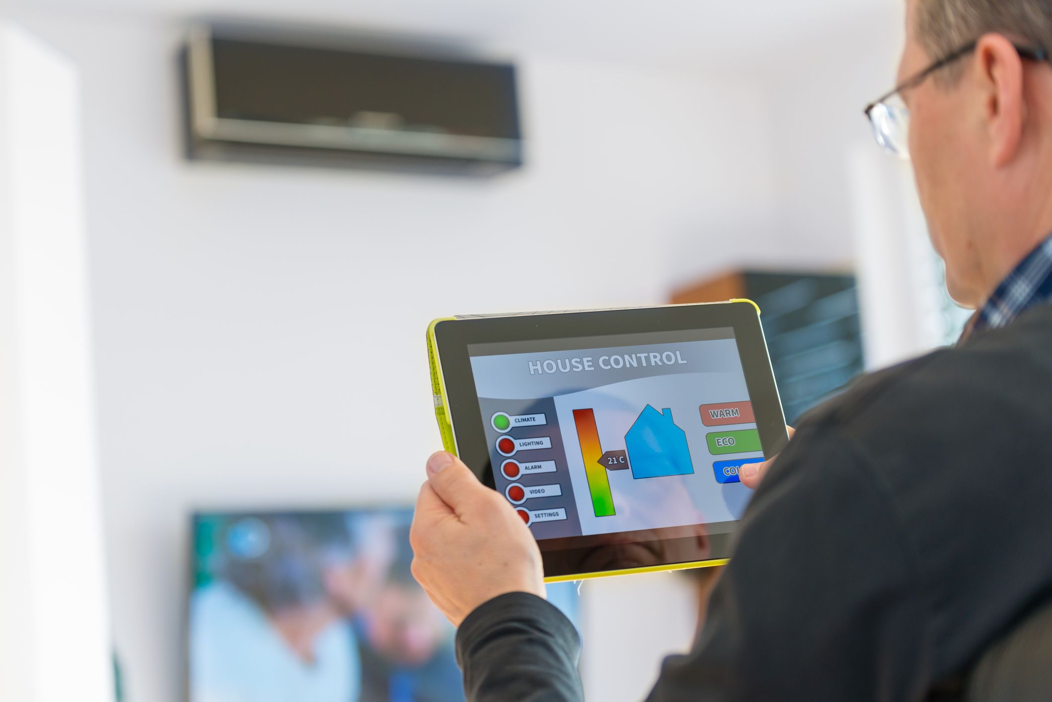 Majitel domu pomocí tabletu ovládá inteligentní klimatizaci ve své domácnosti