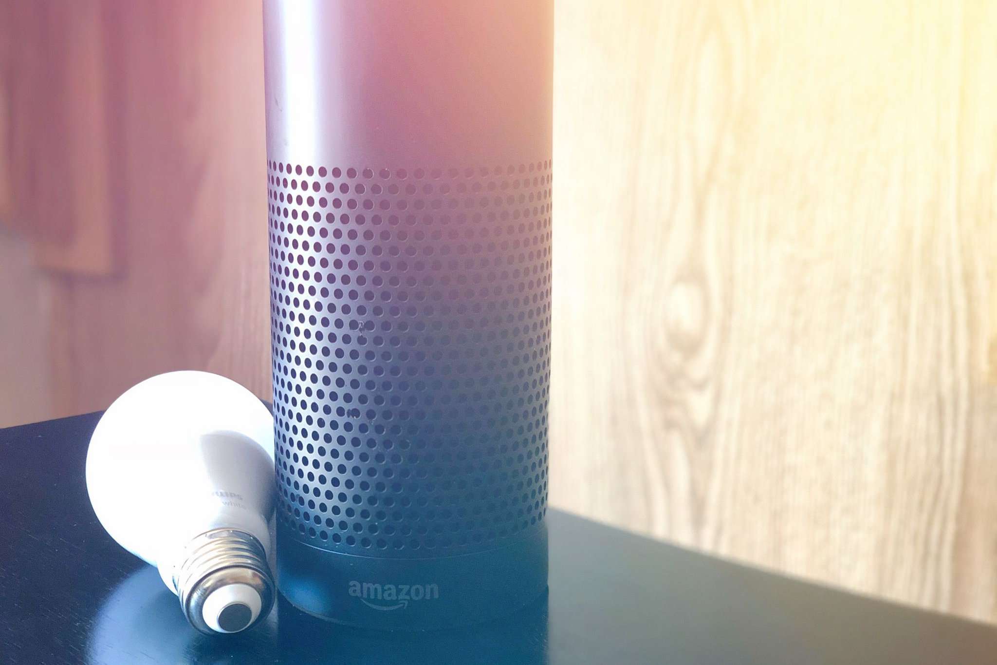 Zařízení Amazon Echo odpočívá vedle inteligentní žárovky