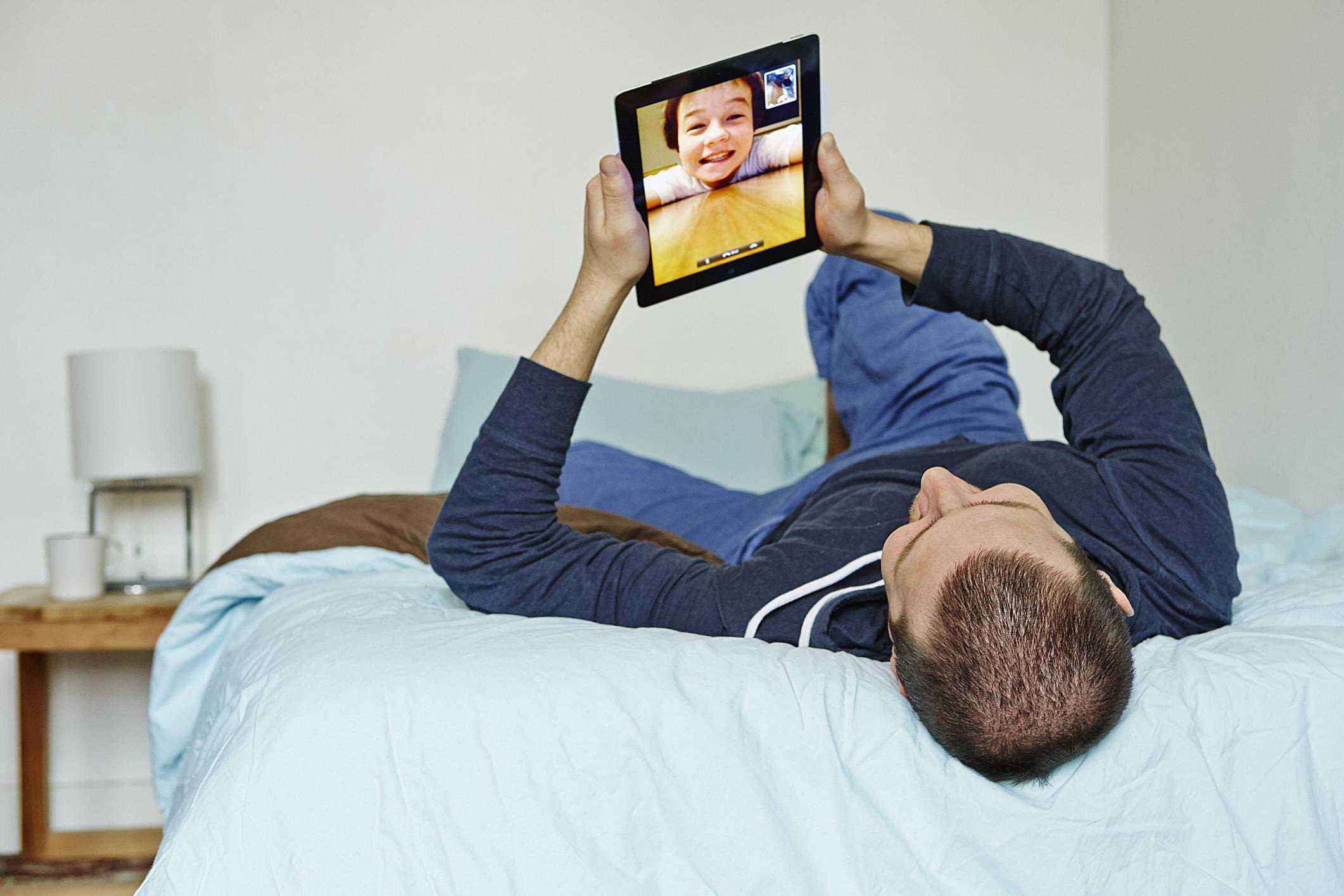Člověk používající iPad k videochatu s mladým chlapcem
