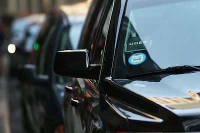 Fotografie zaparkovaného auta řidiče Uber s nálepkou Uber v čelním skle.