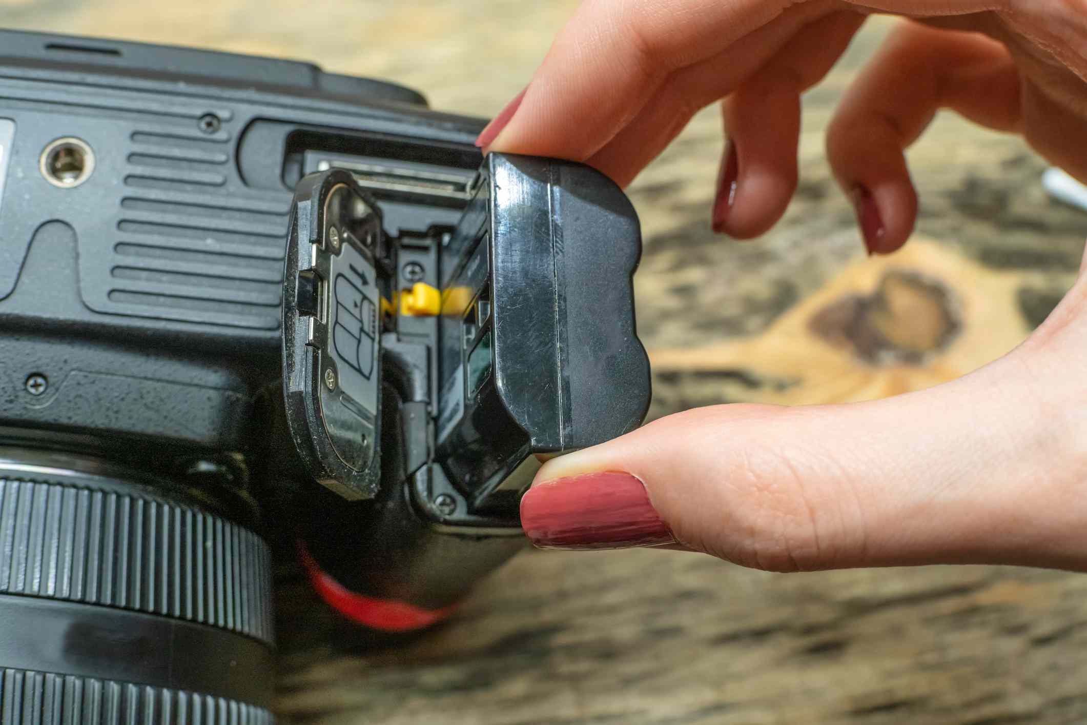 Fotografka mění baterii ve své zrcadlovce