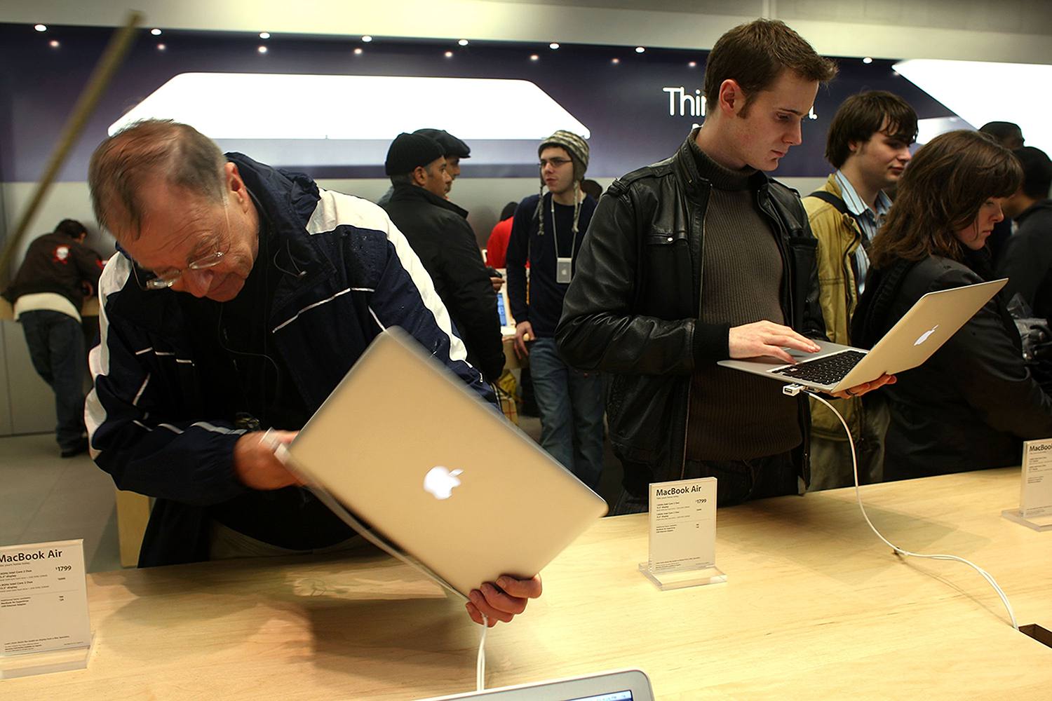 Lidé drží a dívají se na MacBook Air v Apple Store