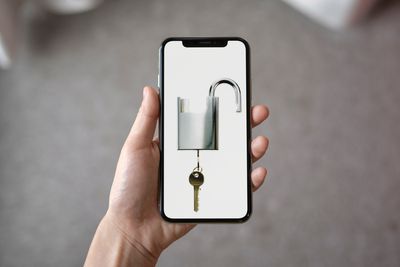 iPhone X s odemčeným visacím zámkem a klíčem na obrazovce