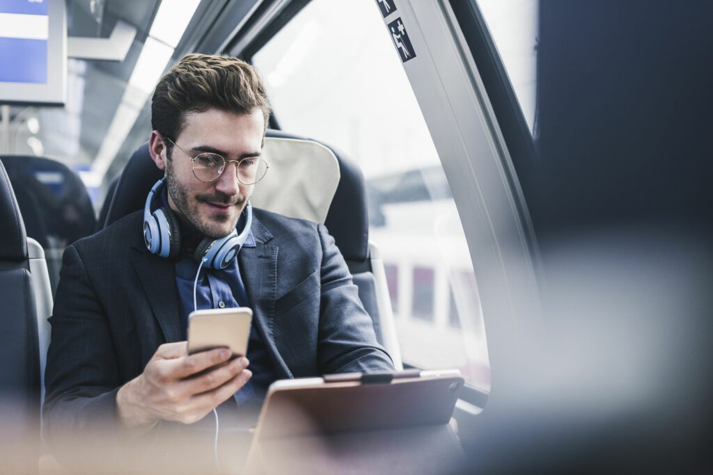 businessman in train with cell phone headphones and tablet 932633170 5b9e7c58c9e77c0050941bea