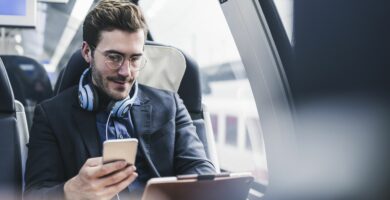 businessman in train with cell phone headphones and tablet 932633170 5b9e7c58c9e77c0050941bea