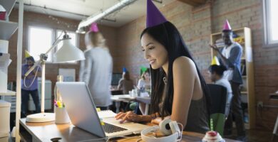 businesswoman wearing birthday party hat at laptop 645426519 5a09fa4c22fa3a003677819c