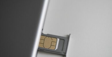 close up of sim card and mobile phone on white table 743692241 5c4cc359c9e77c0001f321e7