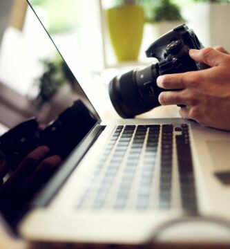 close up photographer hands adjusting settings on his camera in office 918318318 007af521082743cb8abacbf2c7ebb29a