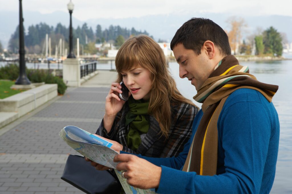 couple reading map on waterfront young woman using mobile phone 200326285 001 5a948525119fa80036dc10c9