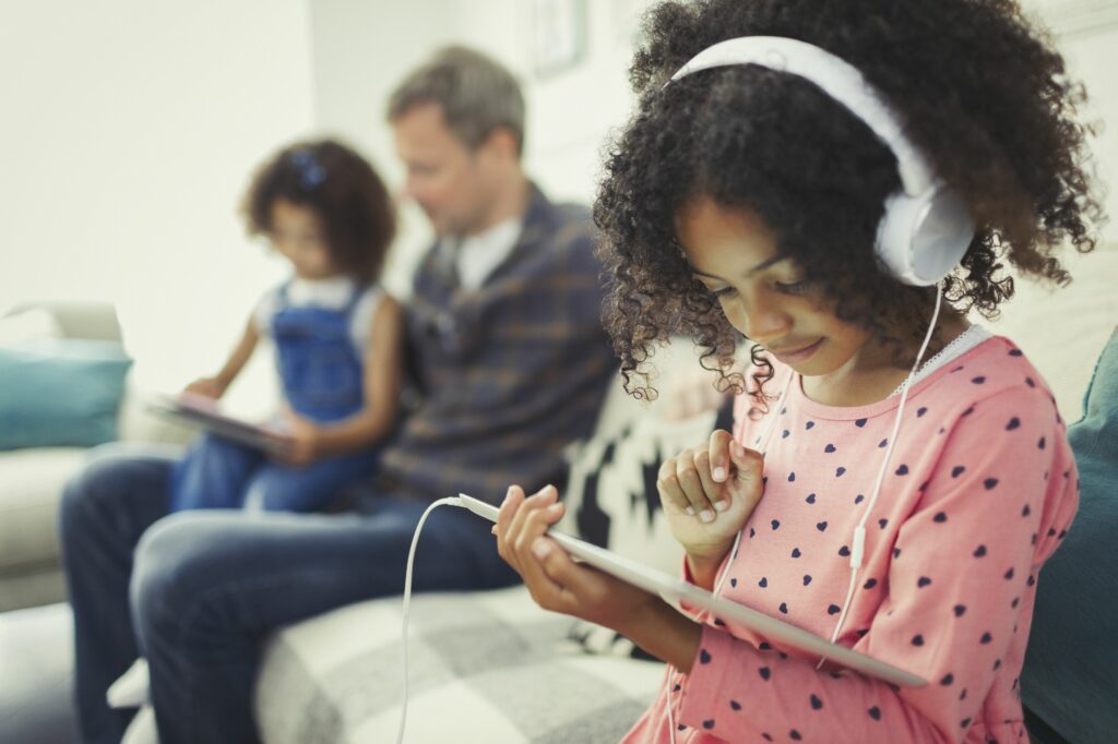 girl with headphones using digital tablet on sofa 726783271 5b3ce2a346e0fb00372de2ba