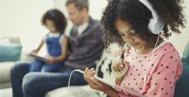 girl with headphones using digital tablet on sofa 726783271 5b3ce2a346e0fb00372de2ba