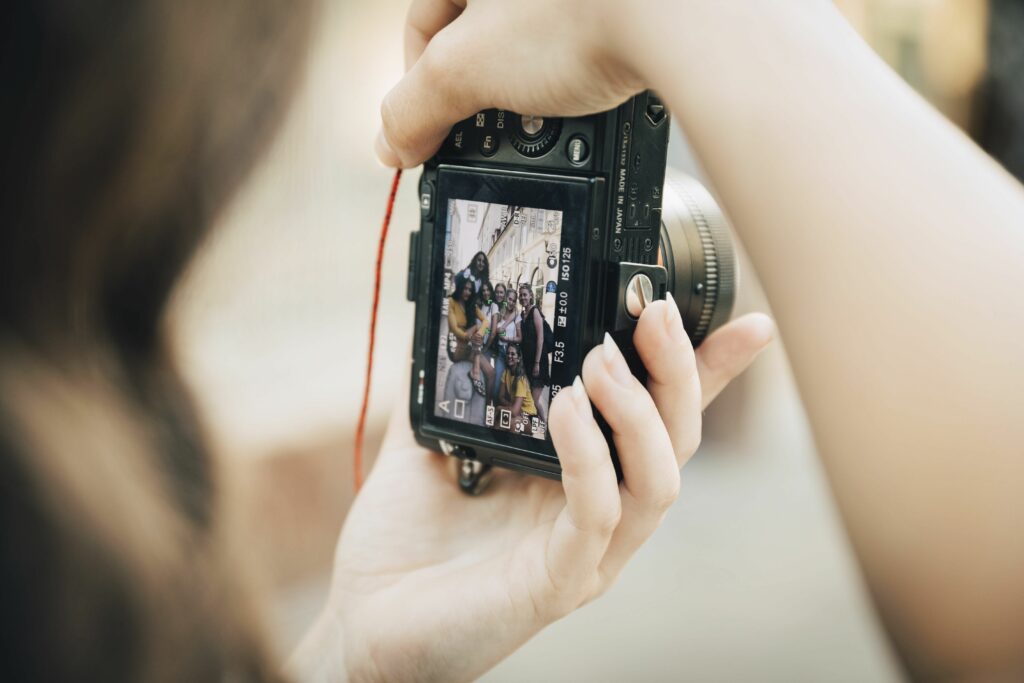 happy friends posing in city seen on slr camera screen 1073873710 2315deaa626745fb9b46236d715adcbe