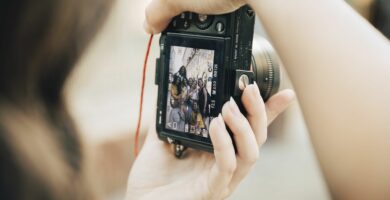 happy friends posing in city seen on slr camera screen 1073873710 2315deaa626745fb9b46236d715adcbe