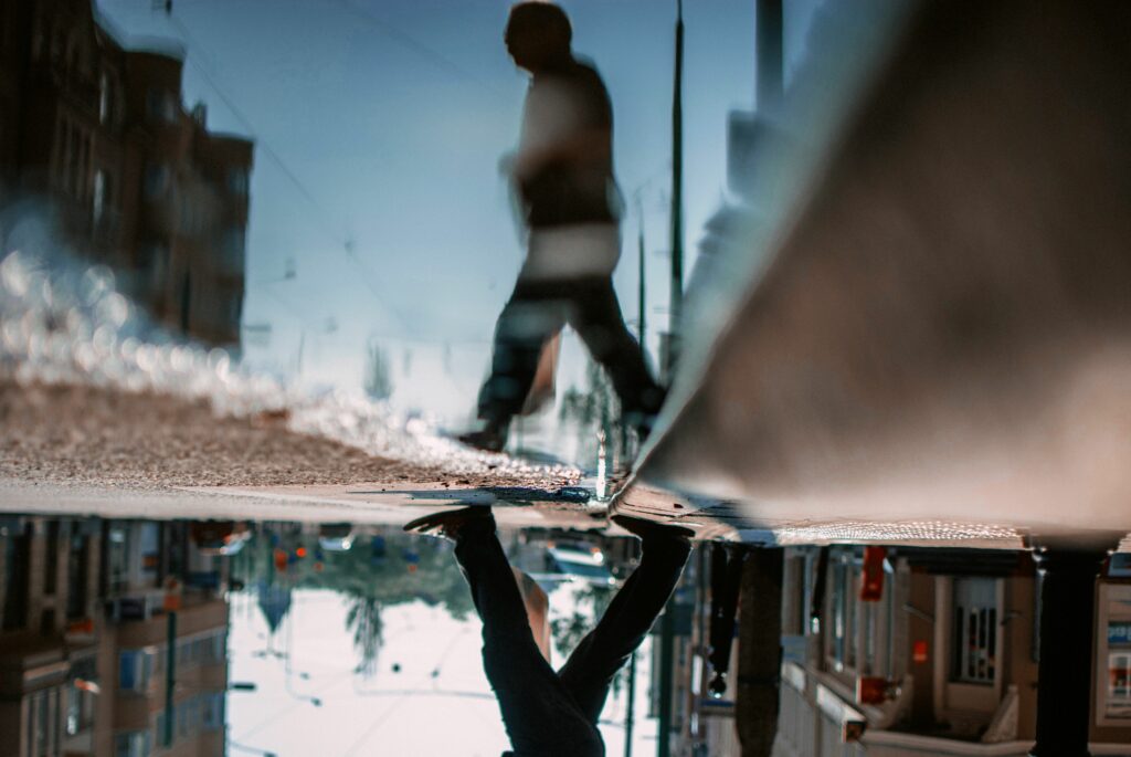 low section of man walking on road with reflection in puddle 758488257 5c2015b846e0fb0001c48d87