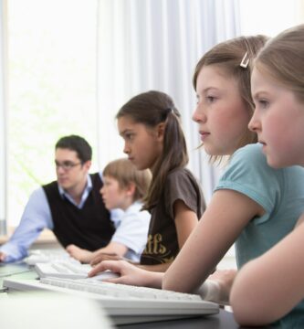 male teacher helping pupils in computer room hamburg germany 98188364 5880eb675f9b58bdb37465ed