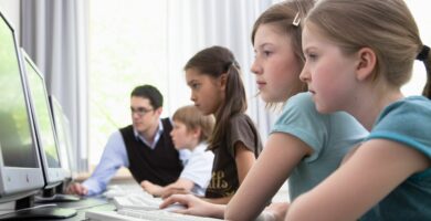 male teacher helping pupils in computer room hamburg germany 98188364 5880eb675f9b58bdb37465ed