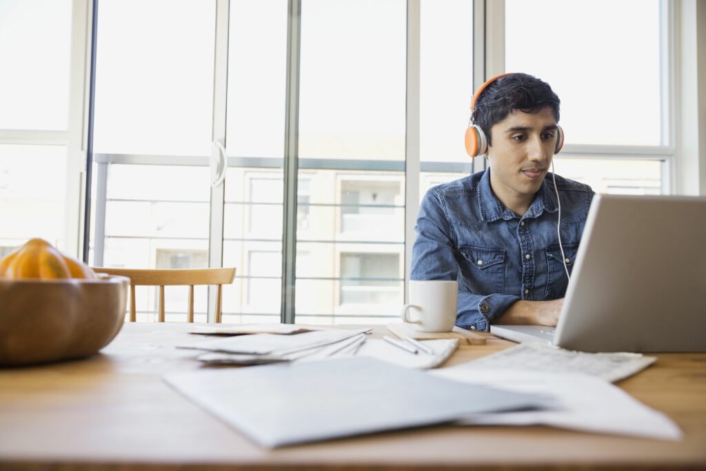 man in headphones using laptop at table 522795487 5b86f7b946e0fb005028ee99