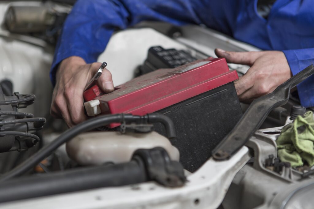 man working on car removing battery 578194587 5ad18e683de4230037b02284