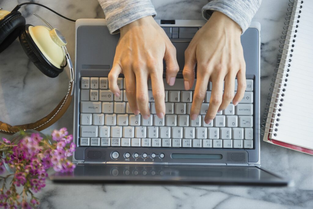 mixed race woman using laptop at table 591404029 5a8d90eb642dca0036707cca