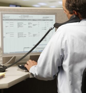 office worker on phone in front of computer 85477093 597c9d13519de2001170612d