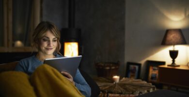 portrait of smiling woman with tablet relaxing on couch in the evening 919443026 5c0964a746e0fb00011af583