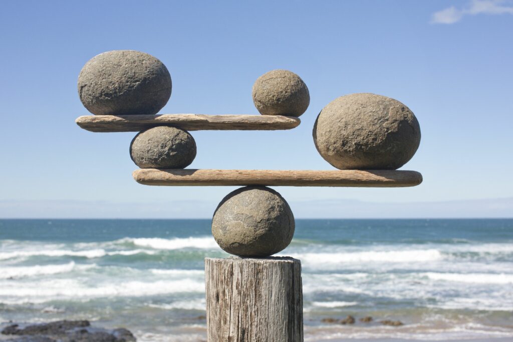 rocks balancing on driftwood sea in background 153081592 591bbc3f5f9b58f4c0b7bb16