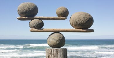 rocks balancing on driftwood sea in background 153081592 591bbc3f5f9b58f4c0b7bb16