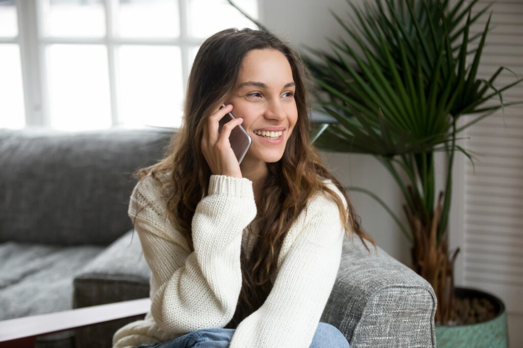 smiling millennial mestizo woman talking on the phone at home 934913078 5afd8c038023b9003692d3c1