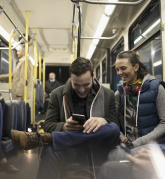 smiling young couple commuters texting with smart phone on bus 900897668 db9bb98059304e5b86181cd2beb3e7e4