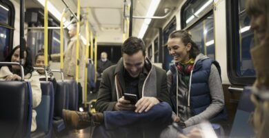 smiling young couple commuters texting with smart phone on bus 900897668 db9bb98059304e5b86181cd2beb3e7e4