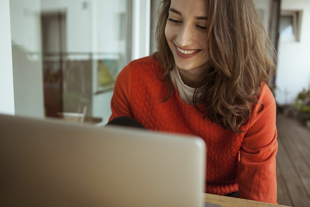 smiling young woman using laptop on balcony 900250042 5bfdc2d946e0fb0026a708d5