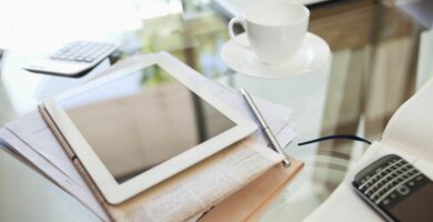 tablet computer newspaper coffee cup and cell phone on desk 175139828 59832b5e519de20011dba56b