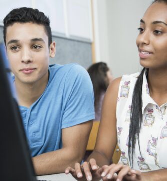 two teenagers working on computer in high school class 592236409 5a2564da0d327a00379e82f4