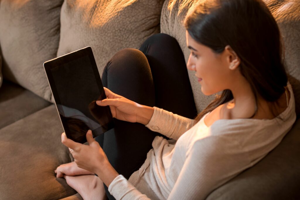 woman sits on couch with tablet 889793946 5b2d3f2c0e23d90036092cb1