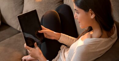 woman sits on couch with tablet 889793946 5b2d3f2c0e23d90036092cb1