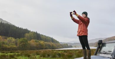 woman standing on car taking photo 690697177 5ad91adc0e23d9003673769e