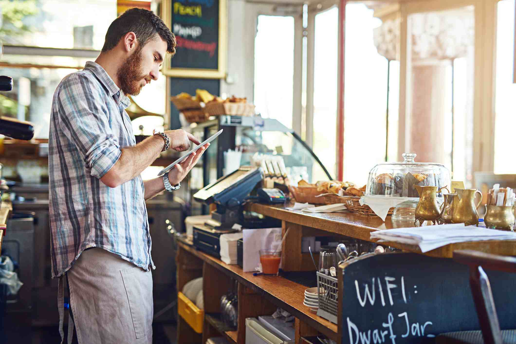 Muž pracující v kavárně pomocí iPadu
