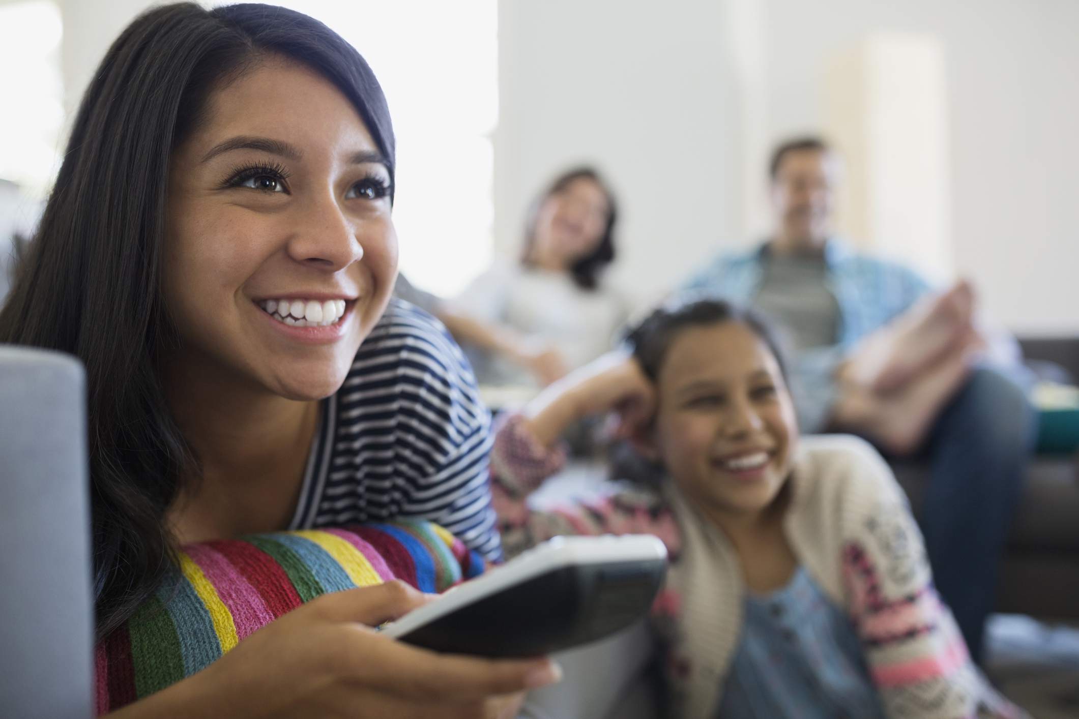 Usmívající se dospívající dívka sledování televize s rodinou