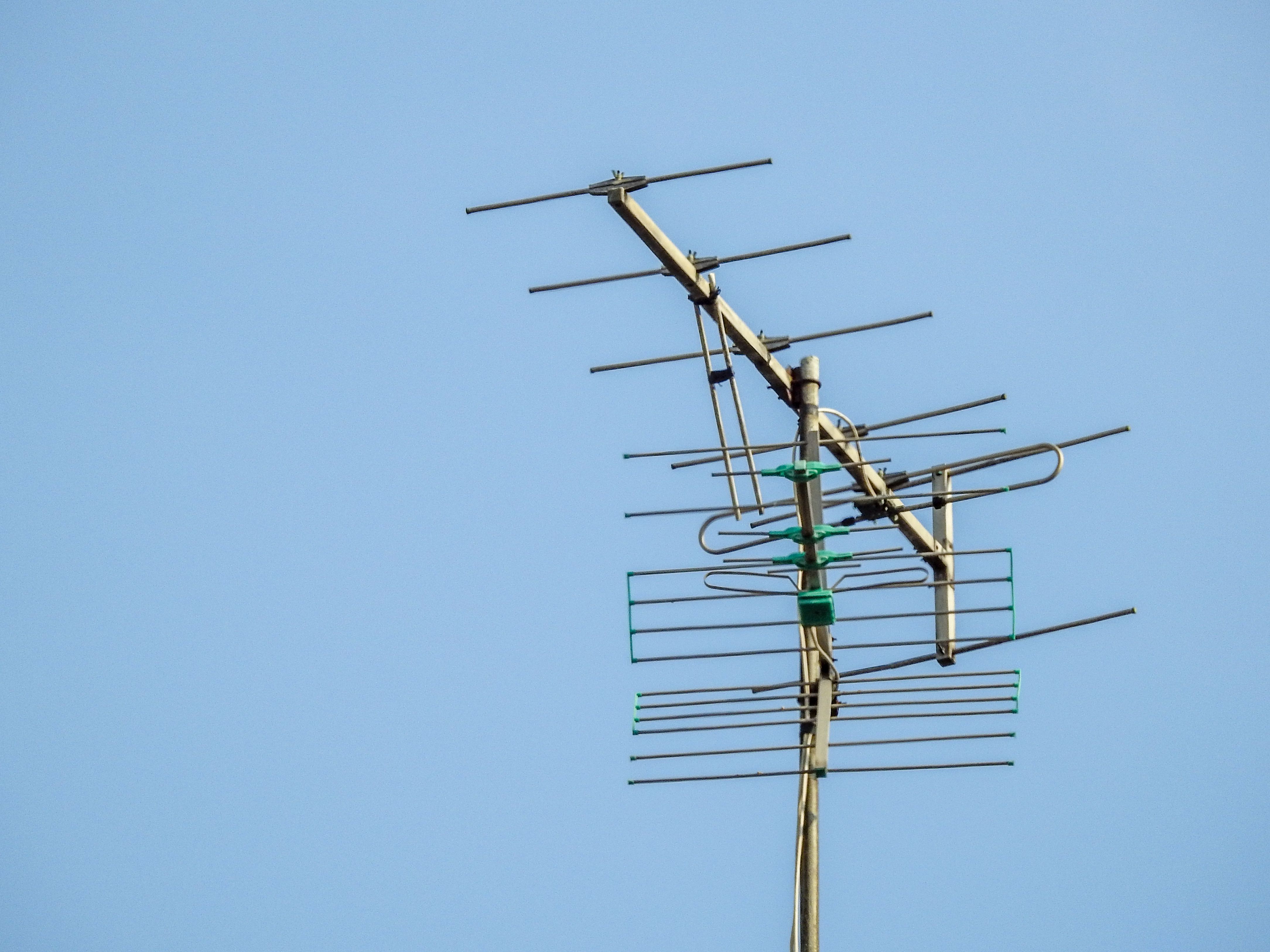 Nízký úhel pohledu na televizní anténu proti jasné obloze