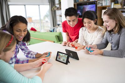 Lidé se shromáždili kolem Nintendo Switch a hráli Mario Kart