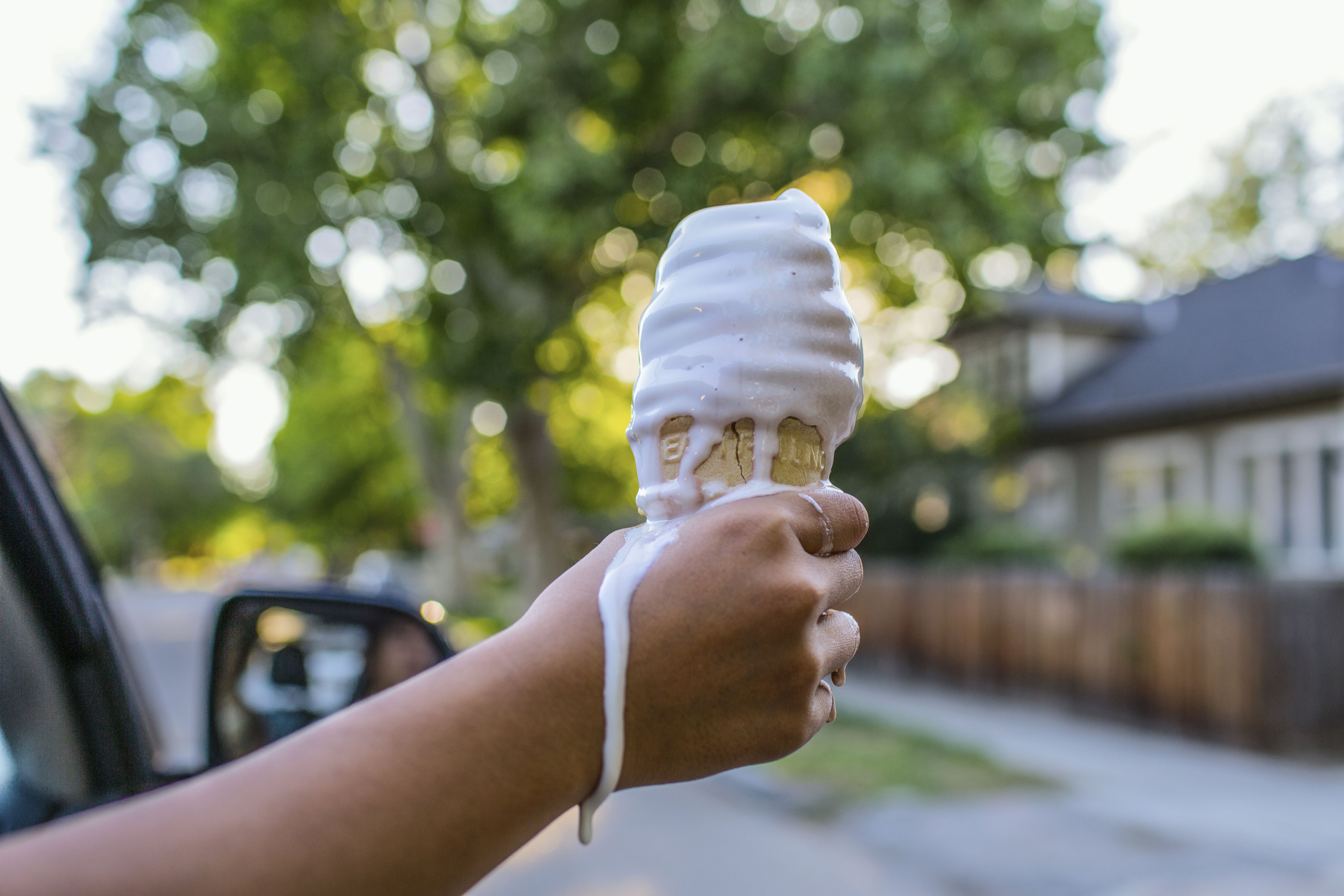 Detail dívčí ruky držící tající kužel zmrzliny