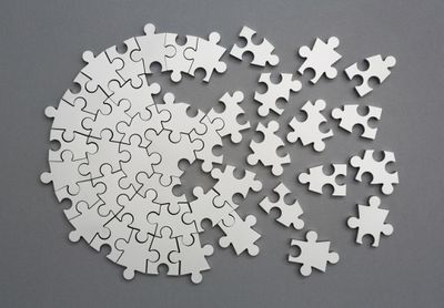Obrázek napůl sestaveného stříbrného kovového puzzle
