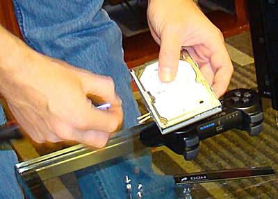 Pomocí křížového šroubováku vyšroubujte čtyři šrouby v přihrádce, které upevňují pevný disk, a vyměňte pevný disk za nový.