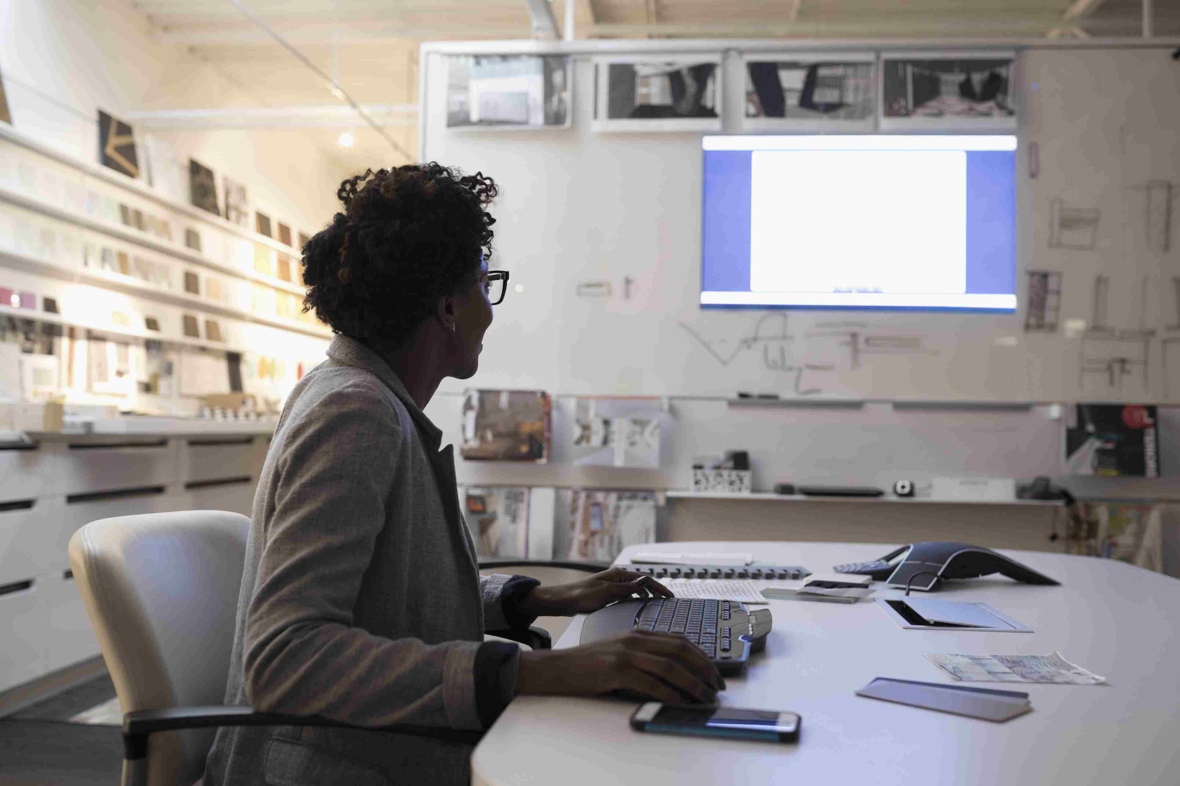 Podnikatelka připravuje prezentační obrazovku v kanceláři